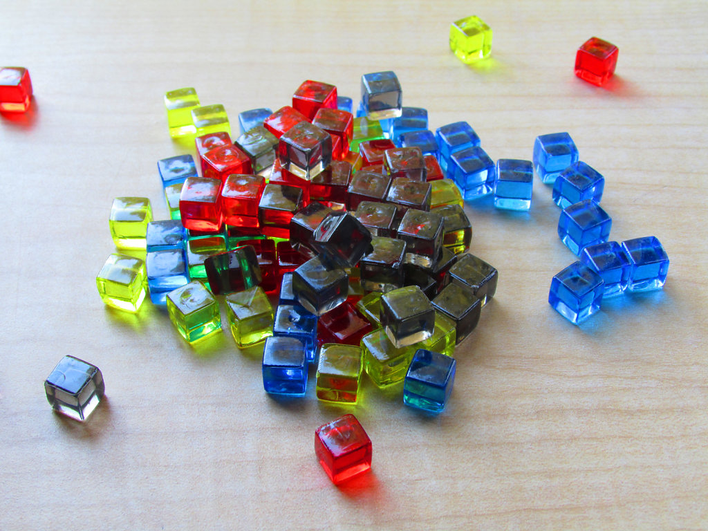 Colored translucent game cubes scattered on a table