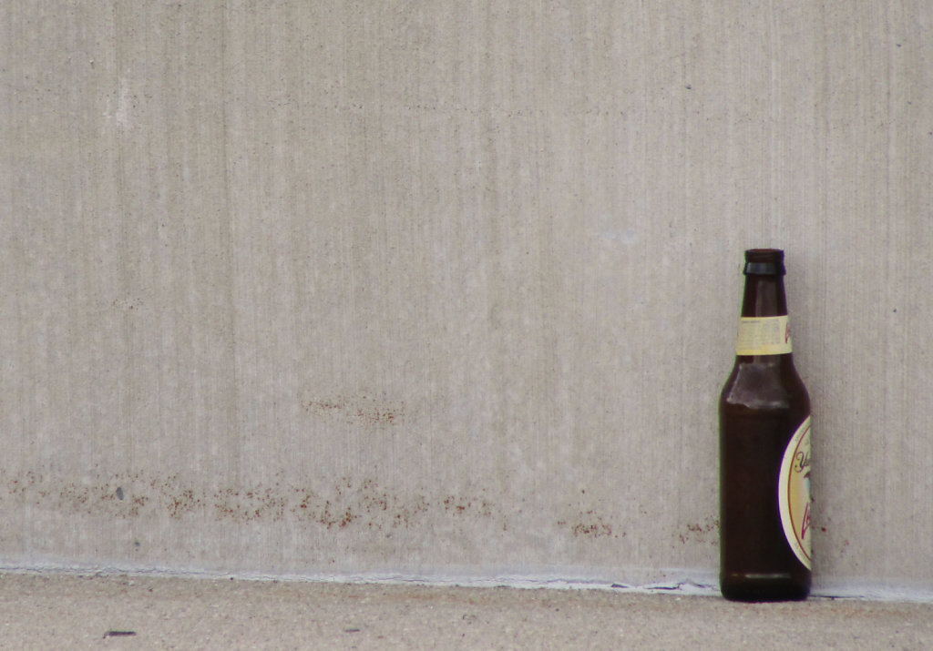 beer bottle against a concrete wall